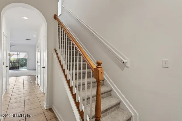 a view of staircase with lots of frames on wall and windows