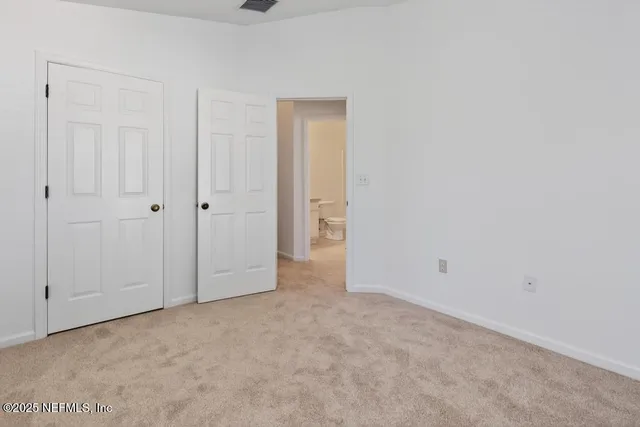 a view of an empty room and closet area