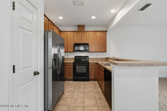 a kitchen with stainless steel appliances granite countertop a stove a refrigerator and a sink
