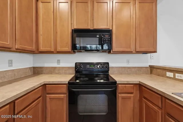 a kitchen with granite countertop a stove sink and cabinets