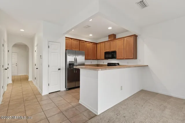 a kitchen with stainless steel appliances granite countertop a refrigerator and a stove top oven