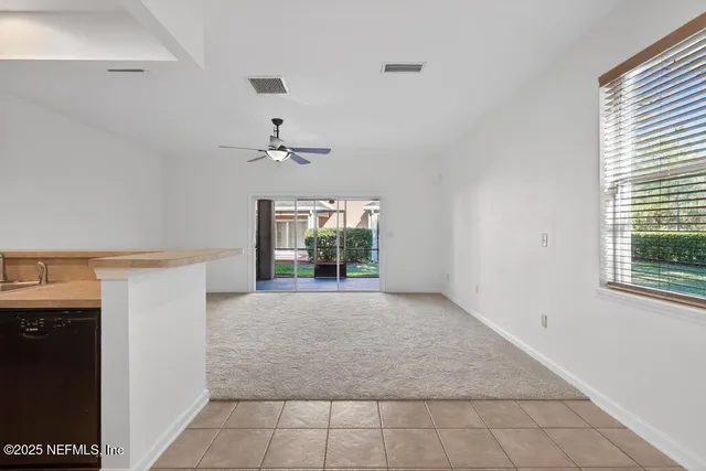 en empty room with windows and fan