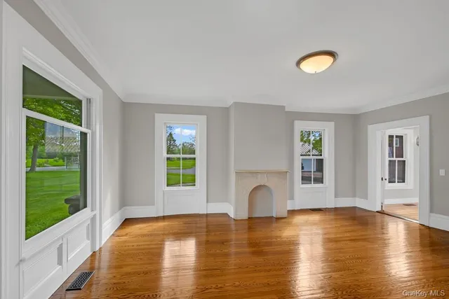 a view of empty room with fireplace and wooden floor