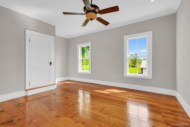 a view of empty room with window and wooden floor