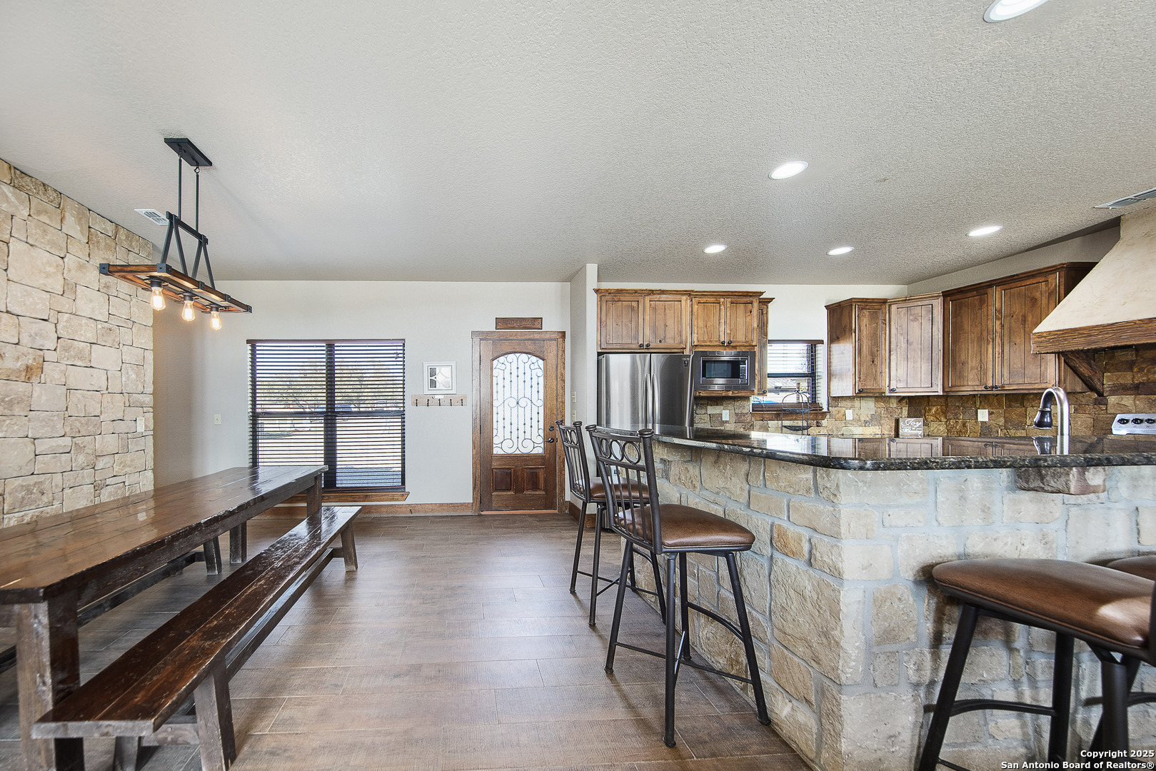24 Morning Dew Concan, TX 78838 - Photo 67 of 88 a kitchen with stainless steel appliances kitchen island granite countertop a table chairs in it and wooden floors