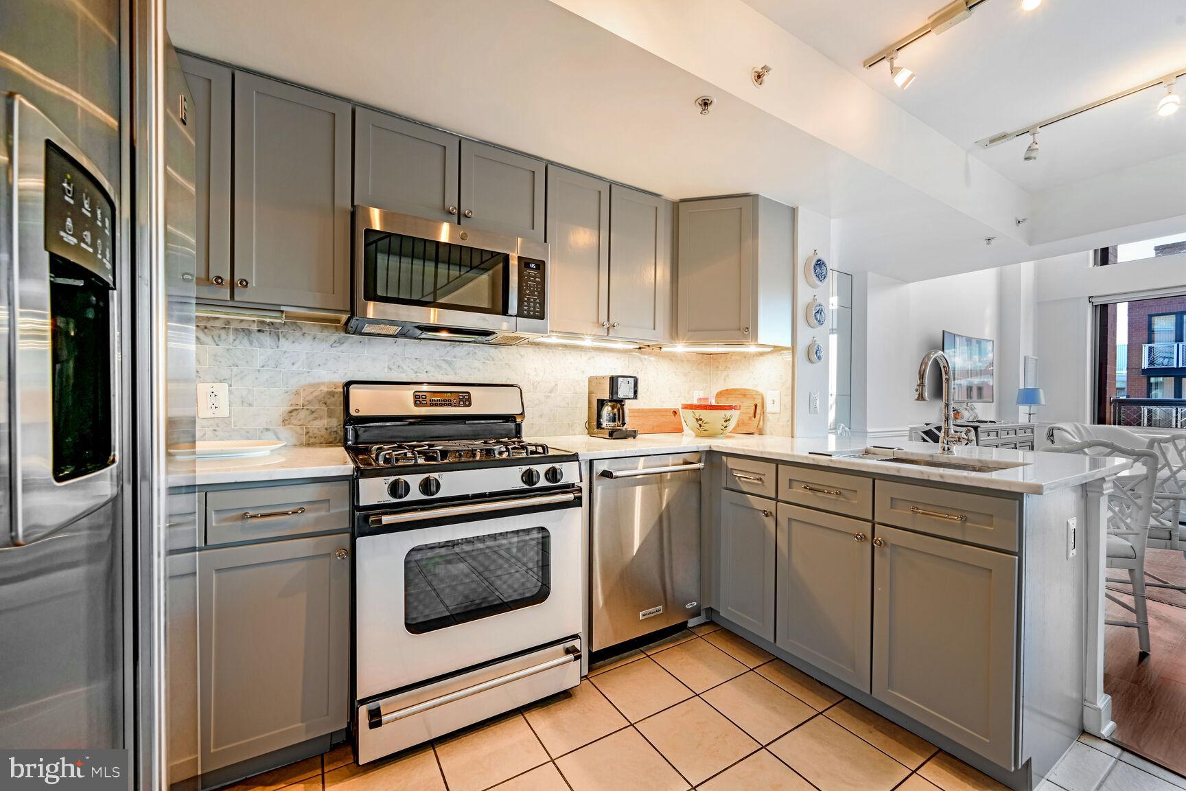616 E Street Northwest, Unit 1150 Washington, DC 20004 - Photo 7 of 75 a kitchen with stainless steel appliances granite countertop a stove a sink and a microwave