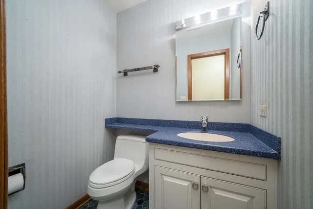 a bathroom with a toilet sink and mirror
