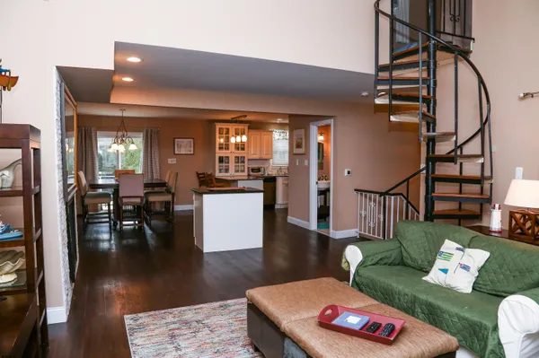 a living room with furniture and a dining table with wooden floor