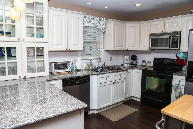 a kitchen with granite countertop a stove sink and cabinets