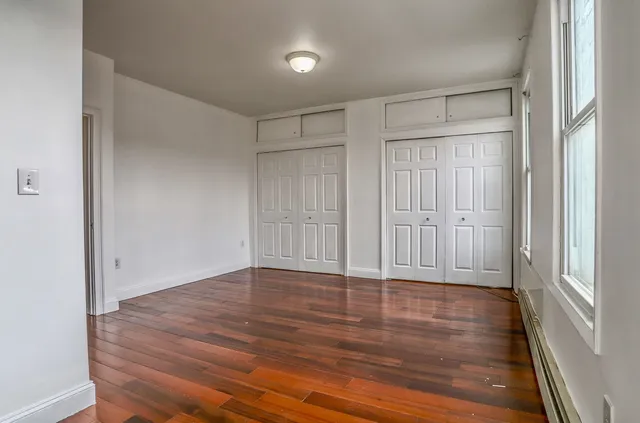 a view of an empty room with wooden floor