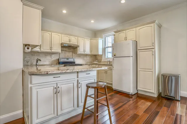 a kitchen with white cabinets and white appliances