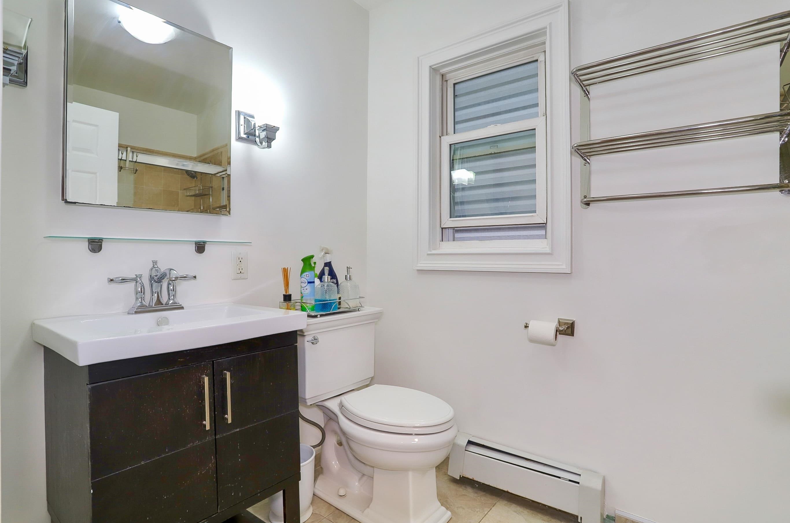 206 Dodd Street, Unit 2 Weehawken, NJ 07086 - Photo 9 of 21 a bathroom with a toilet a sink and mirror