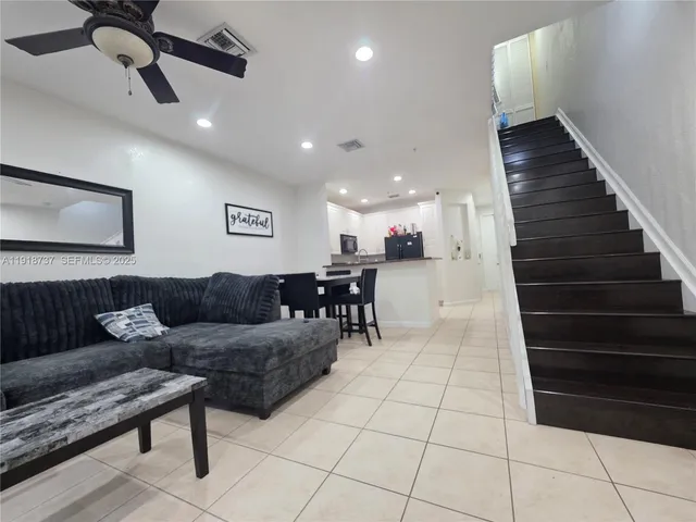 a living room with furniture and a ceiling fan
