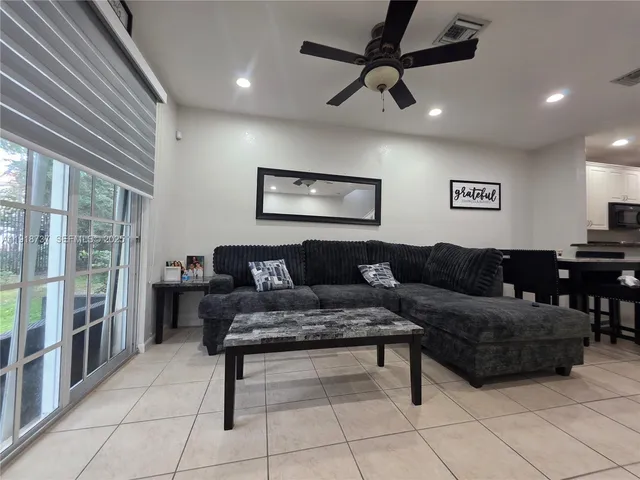 a living room with furniture and a ceiling fan