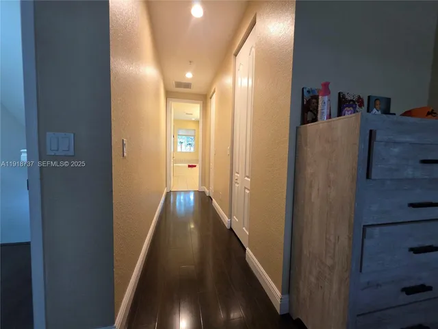 a view of hallway with wooden floor