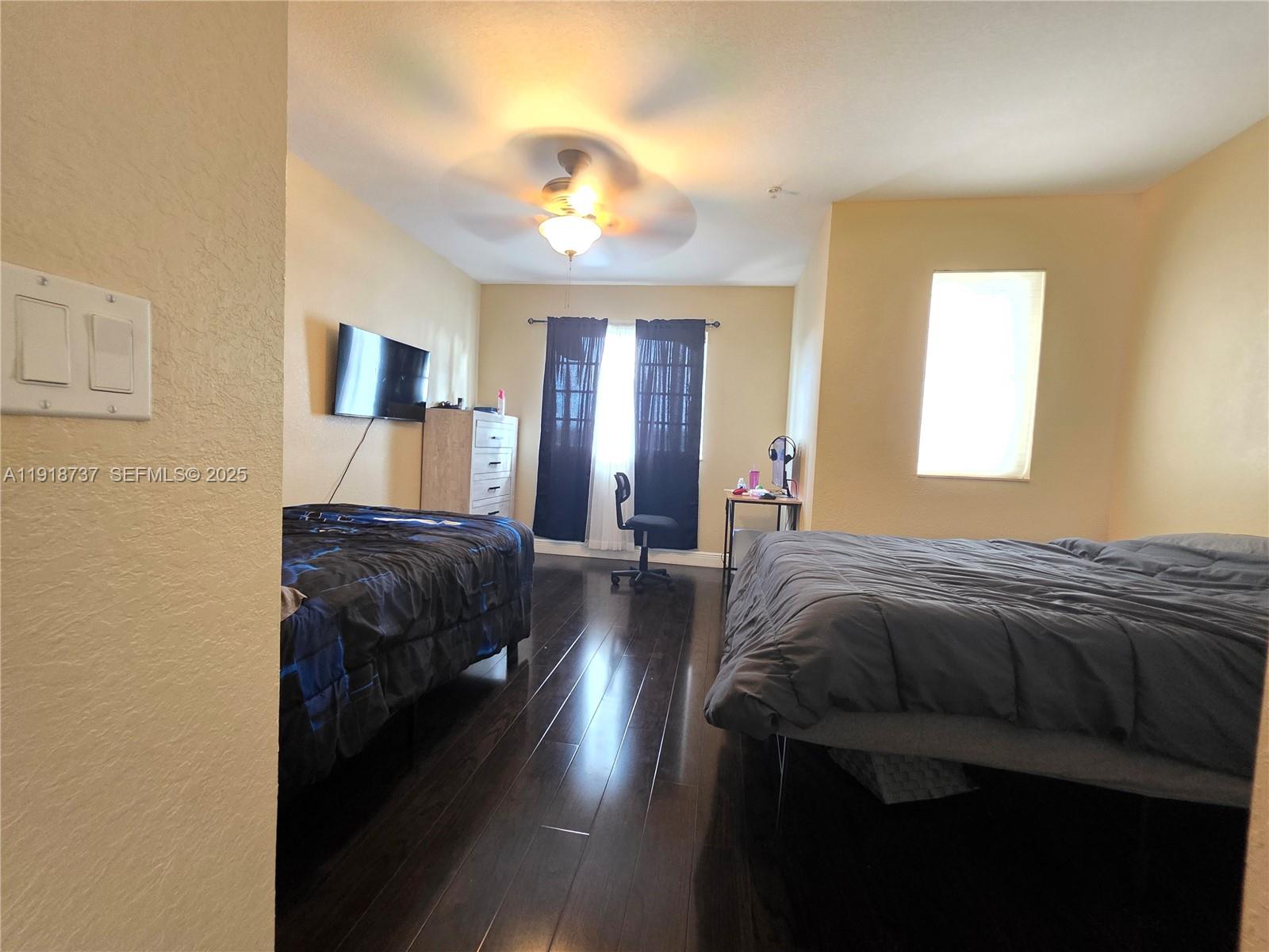 2612 Southwest 81st Terrace, Unit 206 Miramar, FL 33025 - Photo 27 of 40 a bedroom with a bed and a chandelier