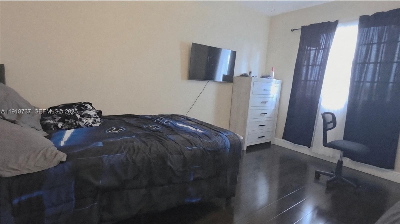 2612 Southwest 81st Terrace, Unit 206 Miramar, FL 33025 - Photo 28 of 40 a bed sitting in a bedroom next to a window with chair and table