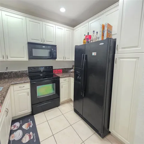 a kitchen with granite countertop a refrigerator and a stove
