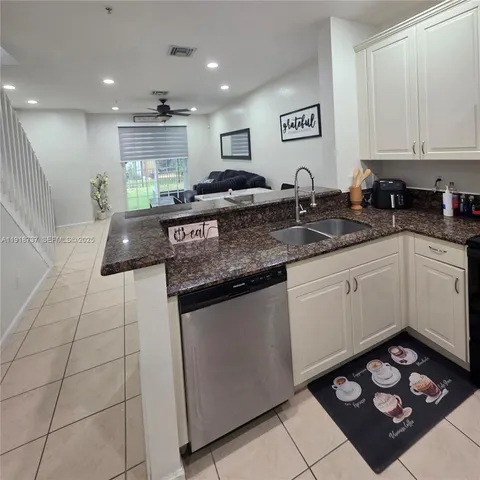 a kitchen with stainless steel appliances granite countertop a sink stove and cabinets