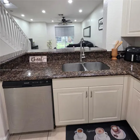 a kitchen with stainless steel appliances granite countertop a sink a stove and a microwave