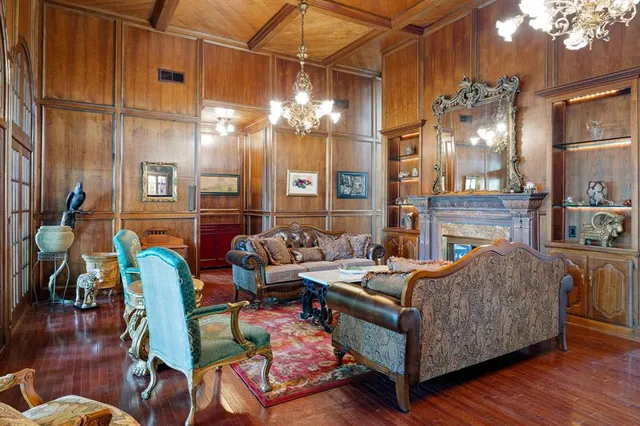a living room with furniture a fireplace and a chandelier