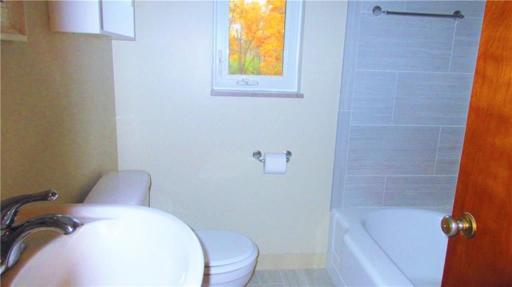 208 Steppland Road Butler, PA 16002 - Photo 13 of 25 Features of the bathroom include a ceramic tile floor, ceramic tile surrounding the tub/shower, and a pedestal sink.