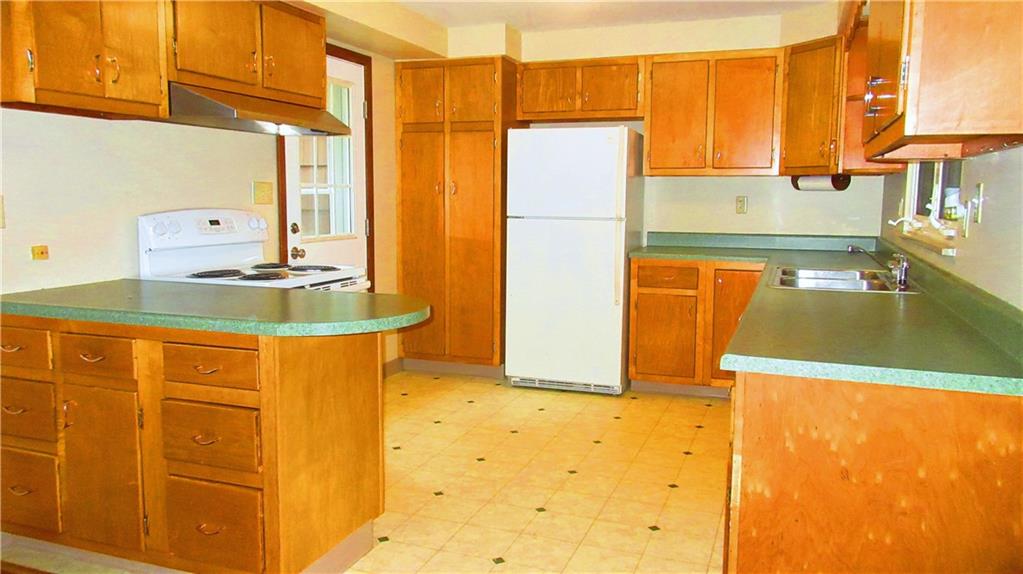208 Steppland Road Butler, PA 16002 - Photo 4 of 25 The kitchen has plenty of cabinets and counter space, a double bowl sink with a large window above it, a peninsula island, a back door, and it's open to the dining room.