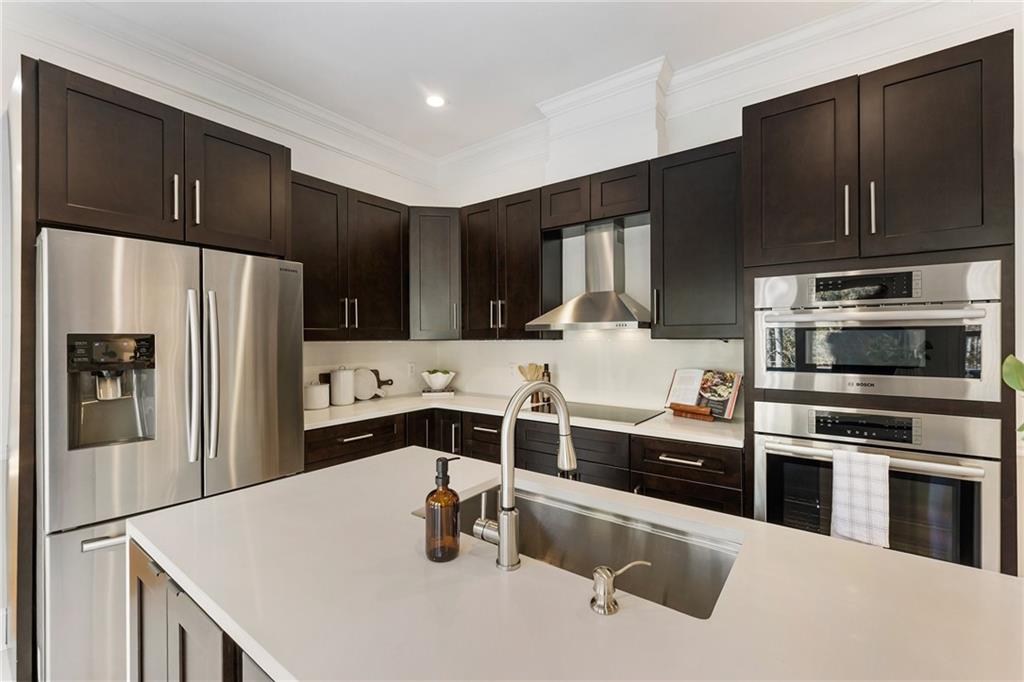 14440 Cogburn Road Alpharetta, GA 30004 - Photo 4 of 62 a kitchen with stainless steel appliances wooden cabinets and a refrigerator