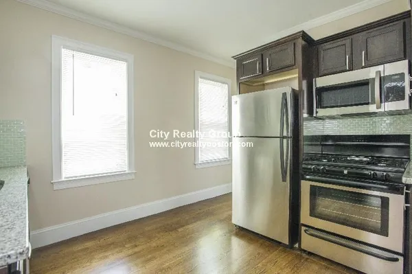 a metallic refrigerator freezer sitting in a kitchen
