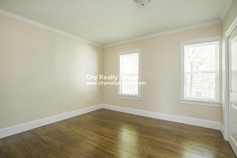 2969 Washington Street, Unit 3 Boston, MA 02119 - Photo 3 of 6 an empty room with wooden floor and windows