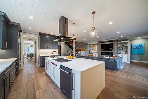 a kitchen with stainless steel appliances granite countertop a sink a stove and a wooden floors