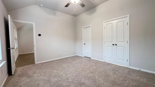 an empty room with windows and fan