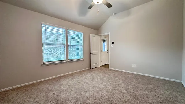 an empty room with windows and fan