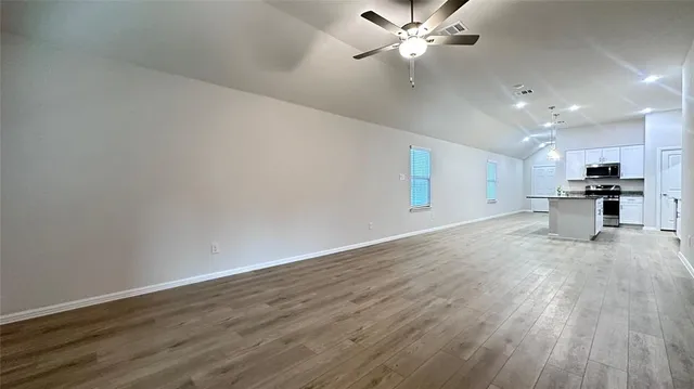 a kitchen with stainless steel appliances granite countertop a sink a stove a microwave a refrigerator and cabinets