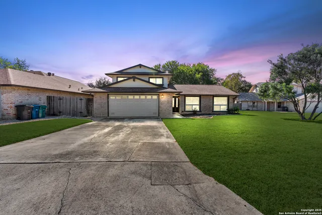 a front view of a house with a yard and green space