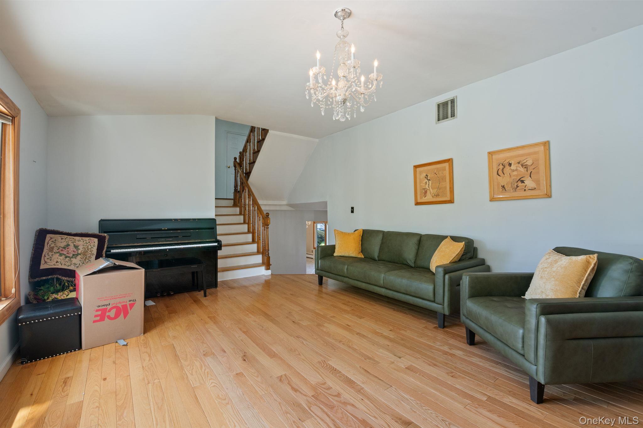 89 Nottingham Road Manhasset Hills, NY 11040 - Photo 19 of 44 a living room with furniture and a chandelier