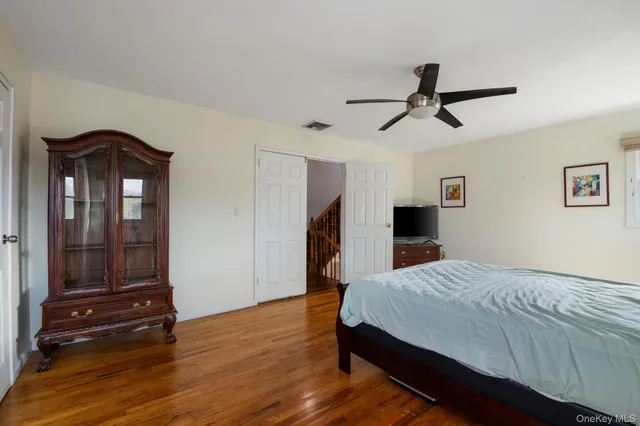 a bedroom with a bed and a mirror on the dresser