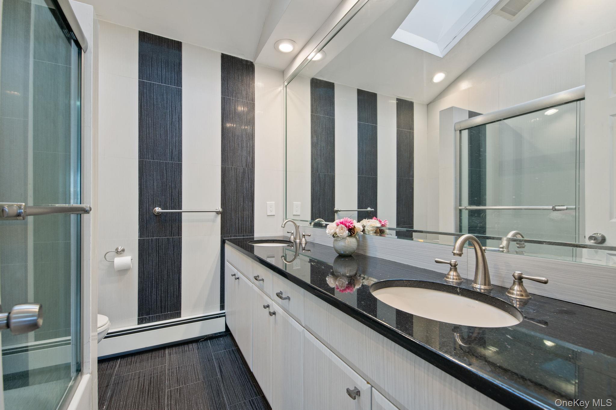 89 Nottingham Road Manhasset Hills, NY 11040 - Photo 23 of 44 a bathroom with a granite countertop sink and a mirror