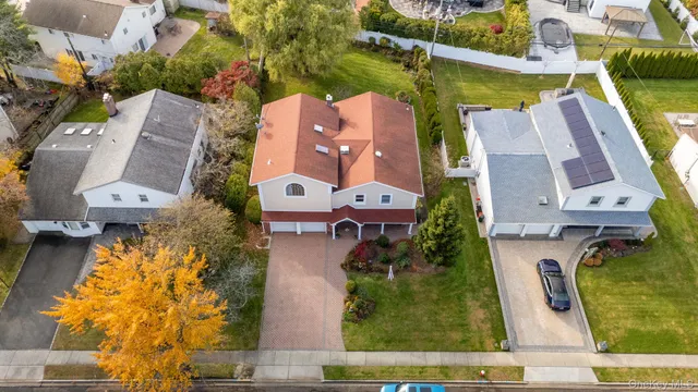 an aerial view of residential houses with outdoor space and parking