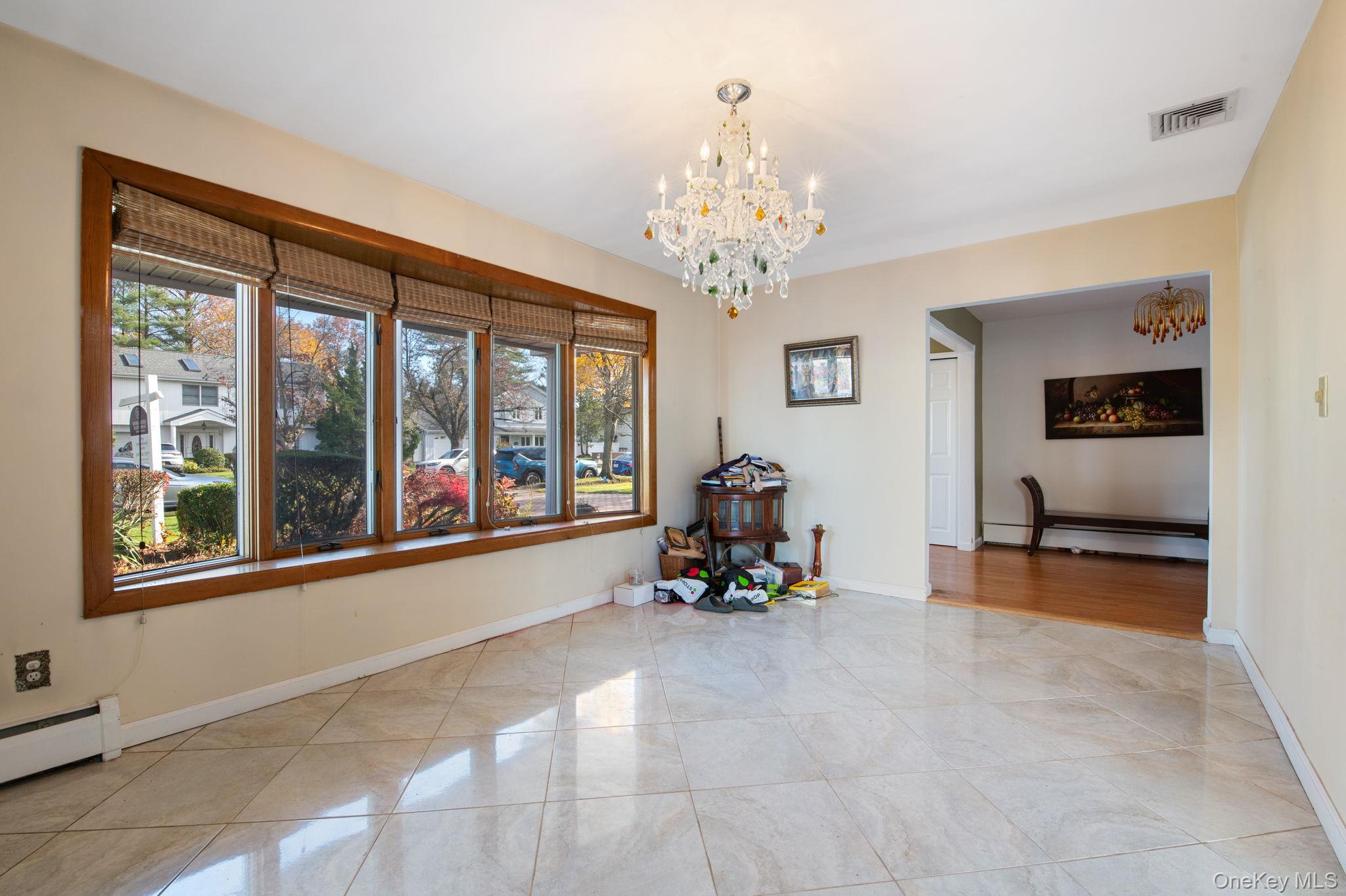 89 Nottingham Road Manhasset Hills, NY 11040 - Photo 4 of 39 Dining area with a chandelier and a baseboard heating unit