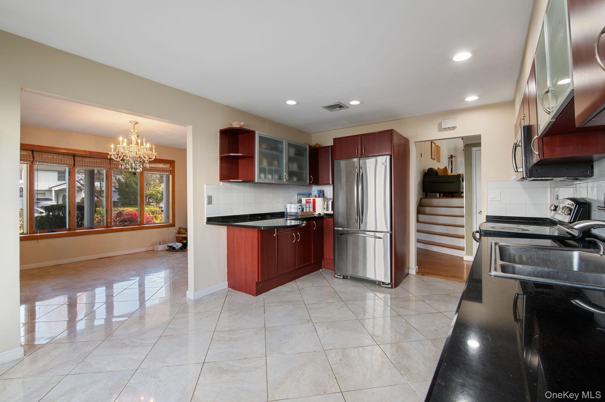 89 Nottingham Road Manhasset Hills, NY 11040 - Photo 9 of 44 a kitchen with stainless steel appliances granite countertop a refrigerator and a stove
