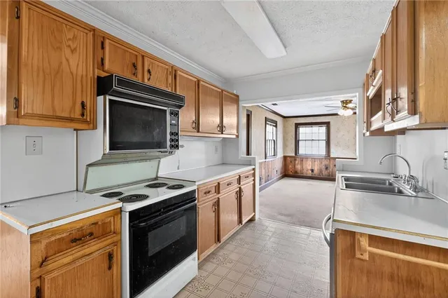 a kitchen with stainless steel appliances granite countertop a stove microwave and sink