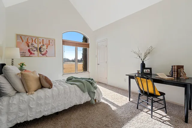 a bedroom with a bed and a mirror on dresser