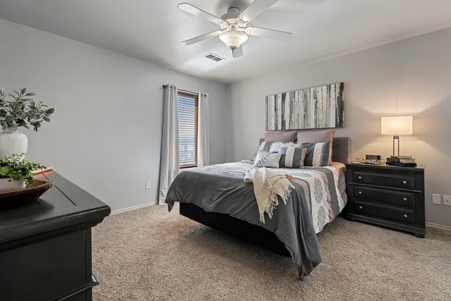 a bedroom with a bed a chandelier and mirror