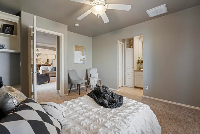 a spacious bedroom with a bed and a flat screen tv