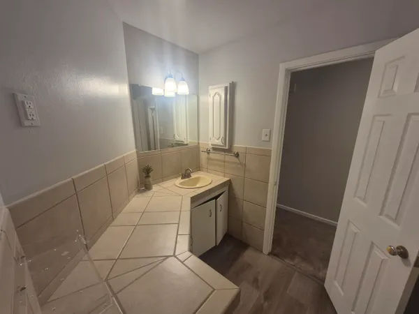 a bathroom with a sink a toilet and a mirror