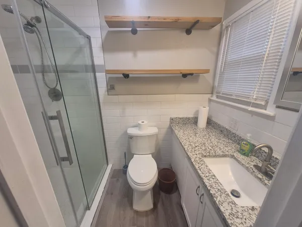 a bathroom with a granite countertop toilet and a sink