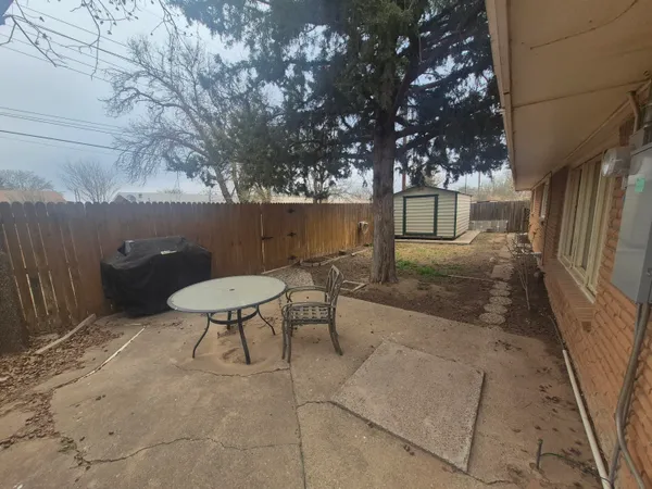 a backyard of a house with table and chairs