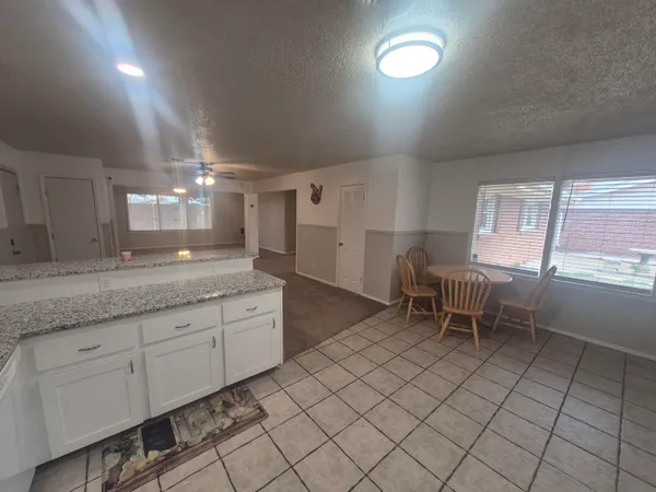 a spacious bathroom with a granite countertop sink a toilet a mirror and a window