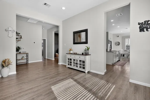 a view of a hallway with wooden floor and furniture